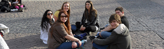 students sitting on cobblestones in spain